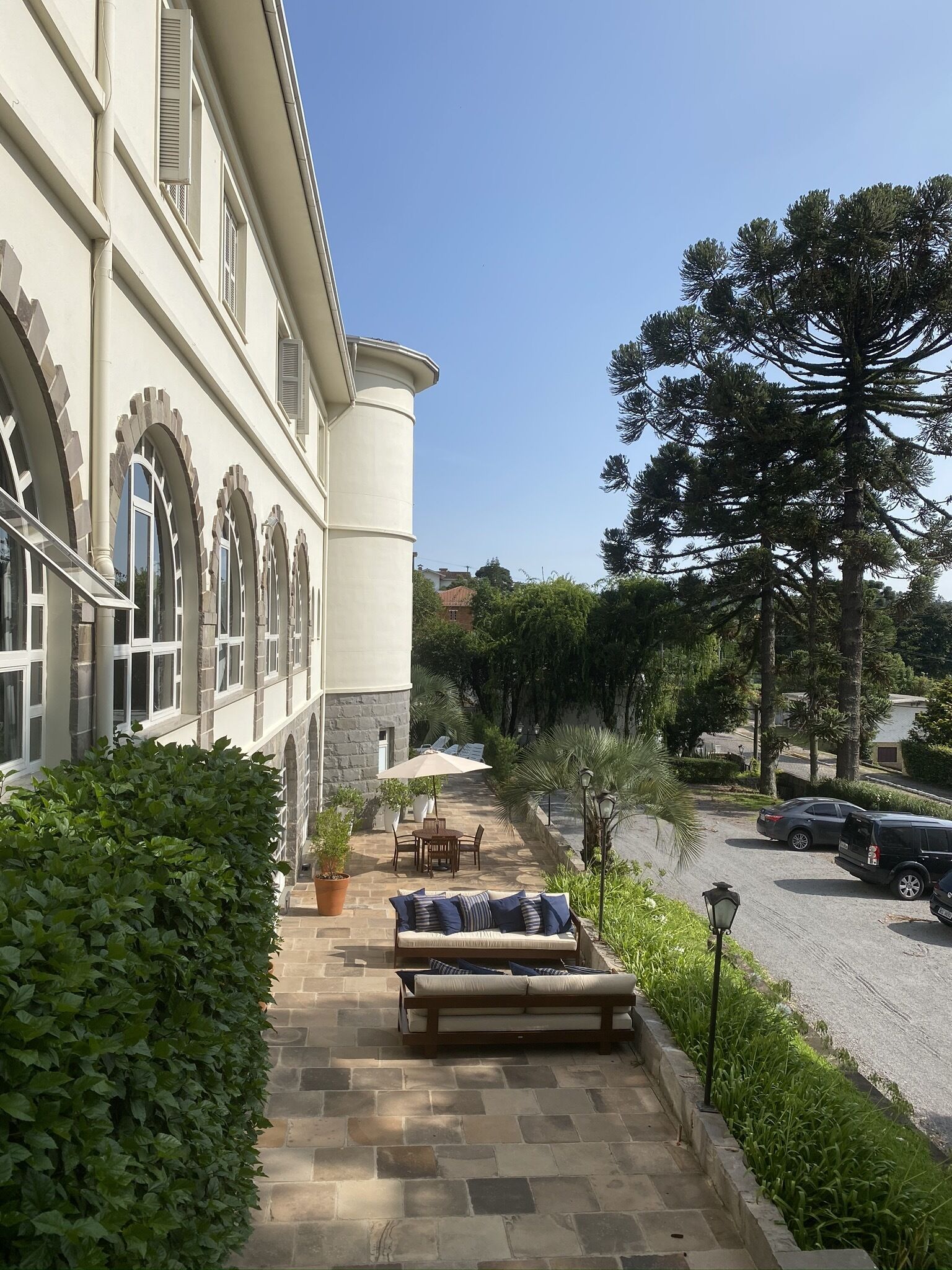 Ein Innenhof mit einer Steinsitzbank, einem Tisch mit Stühlen und einem Blumentopf.