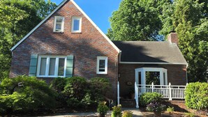 A two-story brick house with a gabled roof, a small porch with a white railing, and a brick chimney. - Full of Character and Convenient to Downtown and HPU.    (High Point)