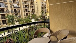 Ein Balkon mit Korbmöbeln und Blick auf Wohnhäuser.