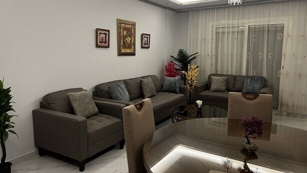Ein modernes Wohnzimmer mit einem großen runden Tisch, Sofas und einer Chandelieber.
