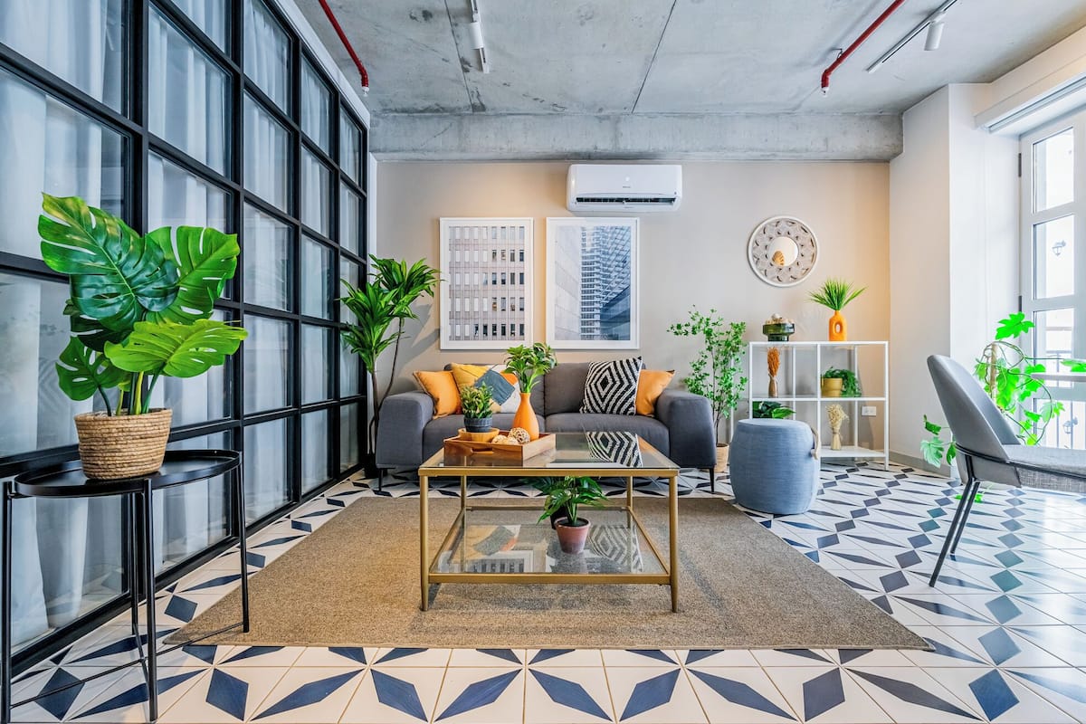 Un salon moderne avec un canapé, une table basse et des plantes en pot.