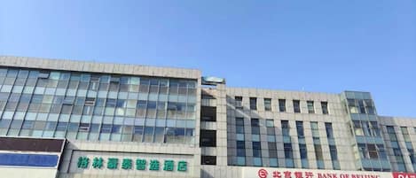 A multi-story building with commercial establishments on the ground floor, including a hotel and a bank.