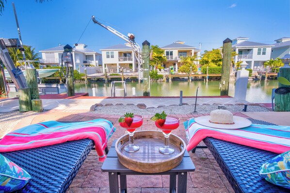 A poolside area with lounge chairs and a table with drinks.
