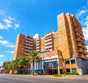 A multi-story hotel with a modern design, featuring balconies on each floor and a prominent entrance with a sign. - Hesperia Morrocoy (Boca de Aroa)