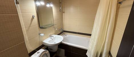 Une salle de bain avec des toilettes, un lavabo et une baignoire.