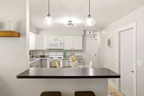 A kitchen with white cabinets, a central island, and pendant lighting. - Caloosahatchee Hideaway II-Waterfront Retreat (Fort Myers)