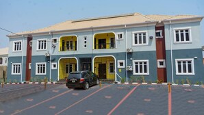 A multi-story building with a parking lot in front. - AJI (1.0)| Luxury 3BED Apartment (Ijegun, Lagos) (Lagos)