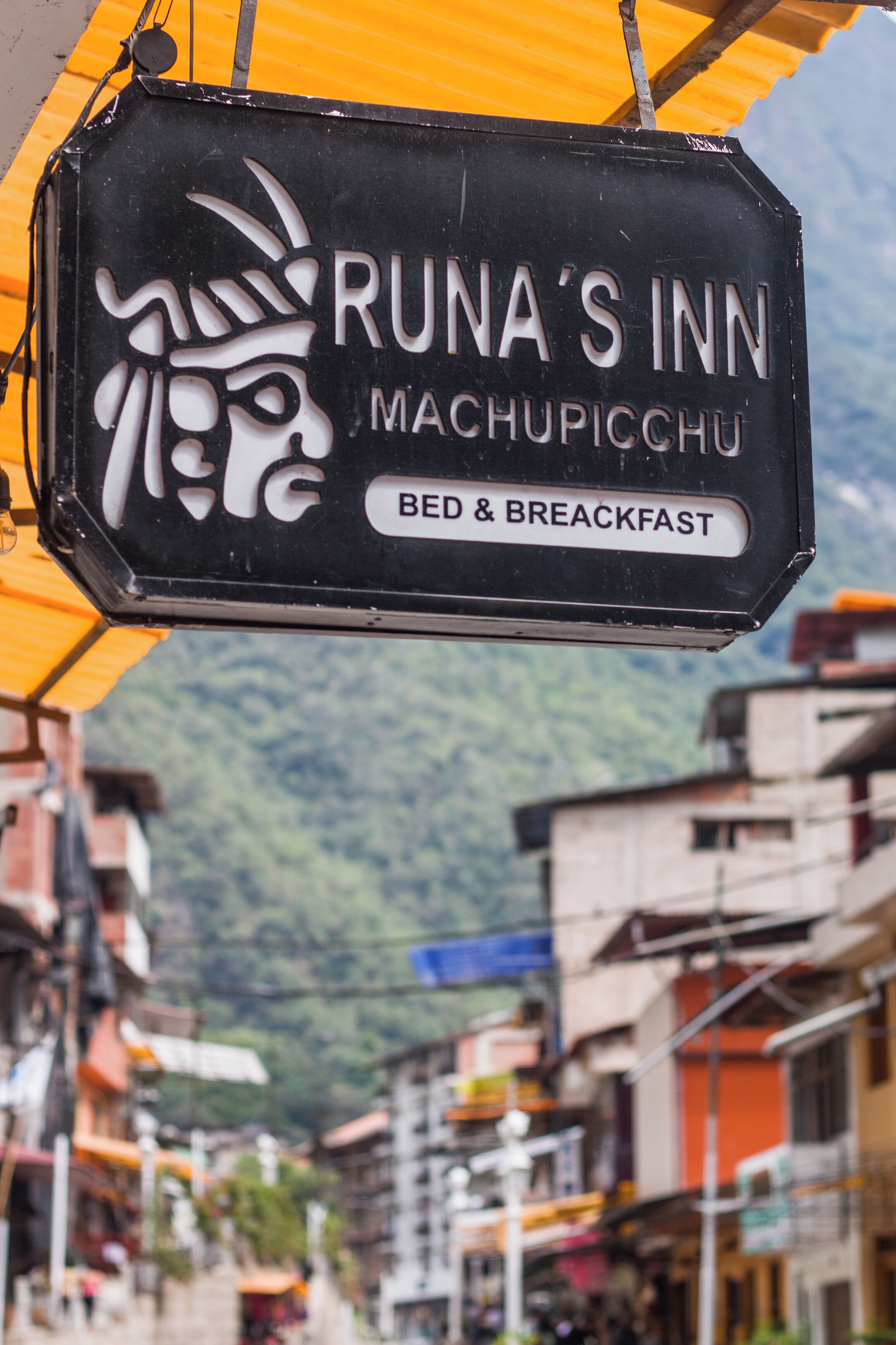 A sign for Runa's Inn in Machupicchu advertising bed and breakfast services.