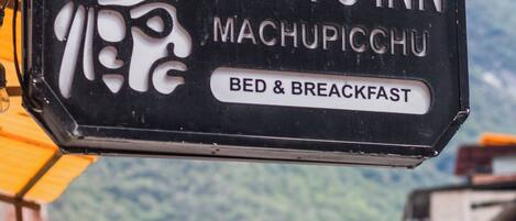 A sign for Runa's Inn in Machupicchu advertising bed and breakfast services.