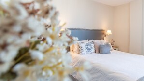 A hotel room with a large bed, a nightstand with a lamp, and a decorative wall. - Phoenix Luxury Loft in Cádiz (Cádiz)