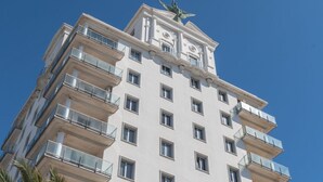 A multi-story building with balconies and a statue on the roof. - Phoenix Luxury Loft in Cádiz (Cádiz)