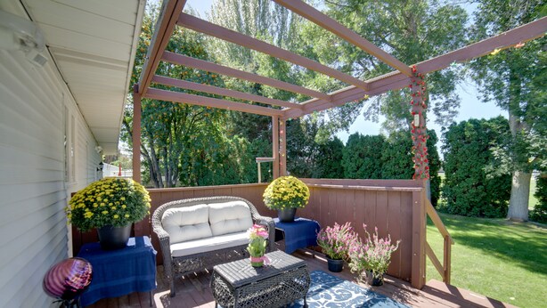 A covered patio with a sofa, a coffee table, and potted plants. - Simple + Charming Idaho Retreat w/ Patio! (Idaho Falls)