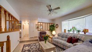 A living room with a sofa, a coffee table, a chair, a ceiling fan, and a window with blinds. - Simple + Charming Idaho Retreat w/ Patio! (Idaho Falls)