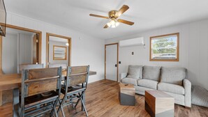 A living room with a wooden dining table, chairs, a sofa, and a ceiling fan. - 2BR Duplex Cabin w/Community Pool + Boat dock (Branson West)