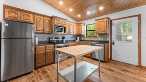 Une cuisine moderne avec des meubles en bois, des appareils électroménagers en acier inoxydable et un îlot central.