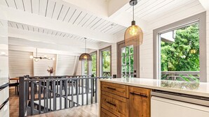 A modern kitchen with wooden cabinets, a white countertop, and large windows offering a view of greenery. - Modern A-Frame, Hot Tub, EV, 10 Guests, Dual King, 8 Mins from Downtown Hendersonville (Hendersonville)