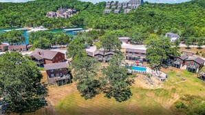 Vue aérienne d’un quartier résidentiel avec des maisons, une piscine et une rivière.
