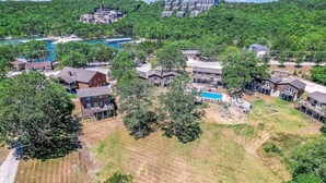 An aerial view of a residential area with houses, a swimming pool, and a river. - 2BR Waterfront Duplex Cabin w/ Pool + Swim & Boat dock (Branson)