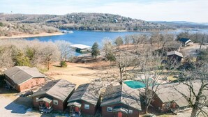 A residential area with multiple houses, a dock, and a large body of water. - 2BR Waterfront Duplex Cabin w/ Pool + Swim & Boat dock (Branson)