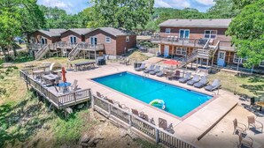 Un espace piscine avec des chaises longues, un barbecue et une terrasse offrant une vue sur les bâtiments environnants.