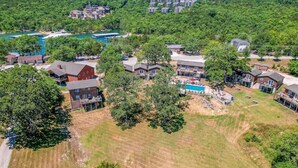 Vista aérea de una zona residencial con casas, una piscina y un río al fondo.