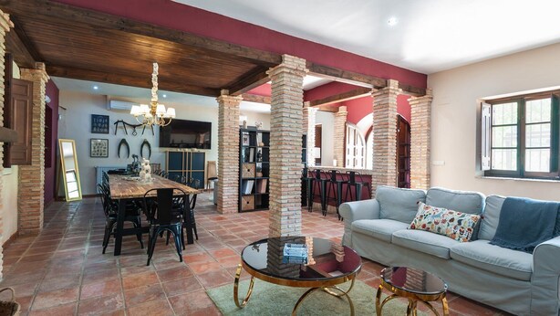 A spacious living area with a dining table, chairs, a sofa, and a coffee table. - Valdemarín Rural Cortijos Nuevos by Ruralidays (Jaén)