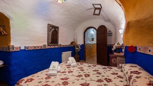 Una habitación con cama, espejo, puerta y ventana.