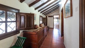A narrow hallway with wooden cabinets and a green chair.