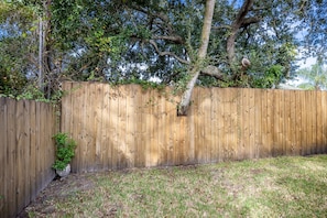 Backyard with a wooden fence and lush greenery.