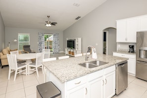 Enjoy meals in the well-lit kitchen with a dining area and oven and sink.