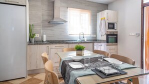 Eine moderne Küche mit Essbereich, ausgestattet mit einer Granitabdeckung, Edelstahlgeräten und einem Fenster für natürliches Licht.