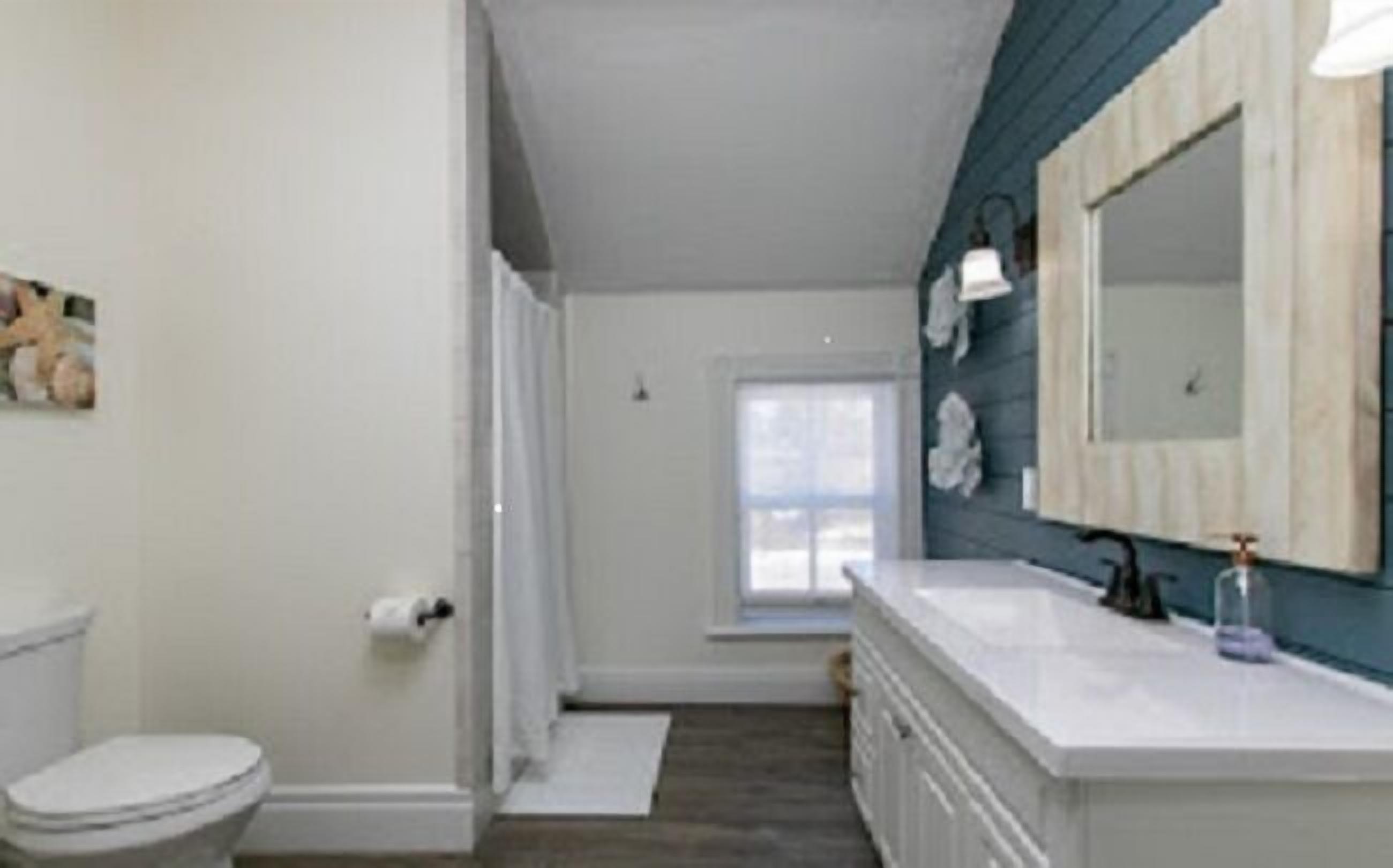A bathroom with a toilet, a sink, and a mirror.