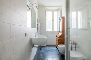 A bathroom with a white sink, a wooden cabinet, and a toilet. - Boutique Apartment Near Spanish Steps (Roma)