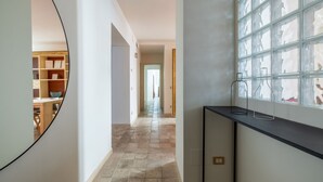 A hallway with a tiled floor, a round mirror, and a window with a grid pattern. - Boutique Apartment Near Spanish Steps (Roma)