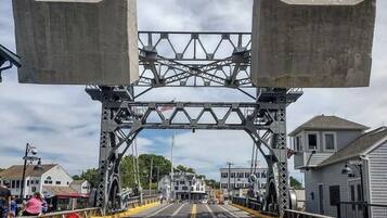 Un puente peatonal con estructura de celosía metálica y soportes de hormigón.