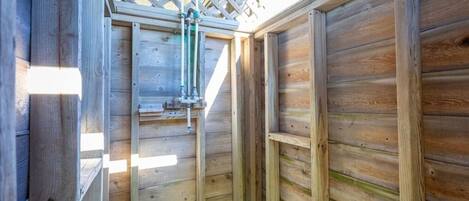 Una estructura de madera con techo de celosía y tuberías visibles.