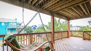 Eine Holzterrasse mit Schaukelstuhl und einer Holzpergola.