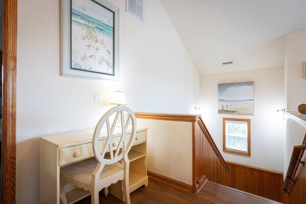 A room with a desk, chair, and a staircase with wooden railings. - Walkable to Beach! Private Pool and Spa, Game Room (Corolla)