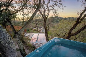 Uma banheira de hidromassagem com vista para uma área residencial e colinas ao fundo.