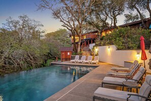 A pool area with lounge chairs and a small wooden structure.