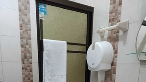 Casa de banho com sanita, lavatório e um contentor de lixo.