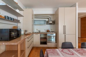 Een microgolfoven, een oven, een kookplaat, kookgerei, borden en bestek