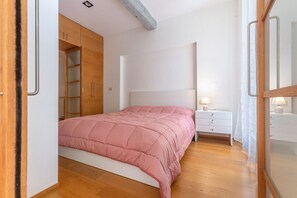 A bedroom with a bed, a nightstand, a dresser, and a wardrobe. - GuestHost - Cozy apartment that accommodates up to 4 people, located in a typical Bolognese building and equipped with all comforts for a pleasant stay, including an internal garden for exclusive use. The accommodation is located in Pratello, one of the  (Bologna)