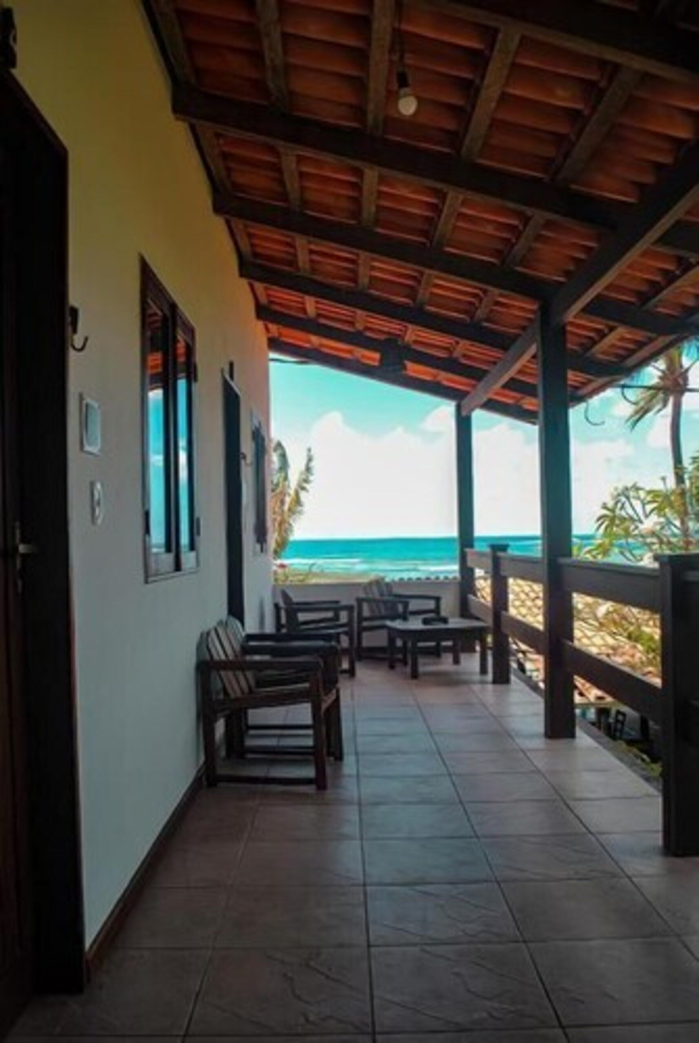 A covered outdoor seating area with a view of the beach.