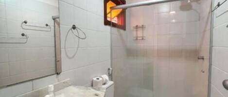 A modern bathroom with a glass shower enclosure, a white sink, and a toilet.