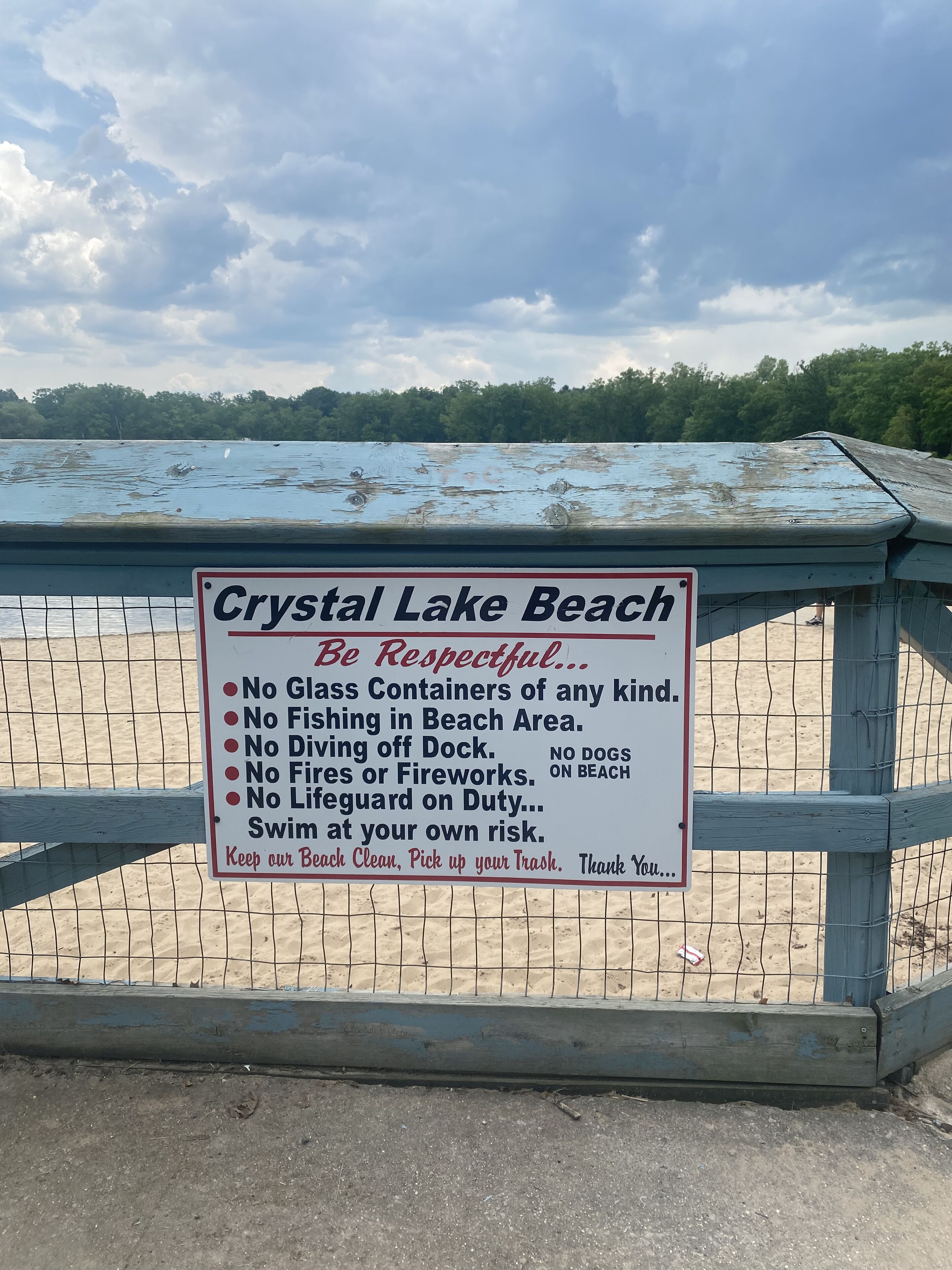 A sign at Crystal Lake Beach with rules like no glass containers, no fishing, and no dogs on the beach.
