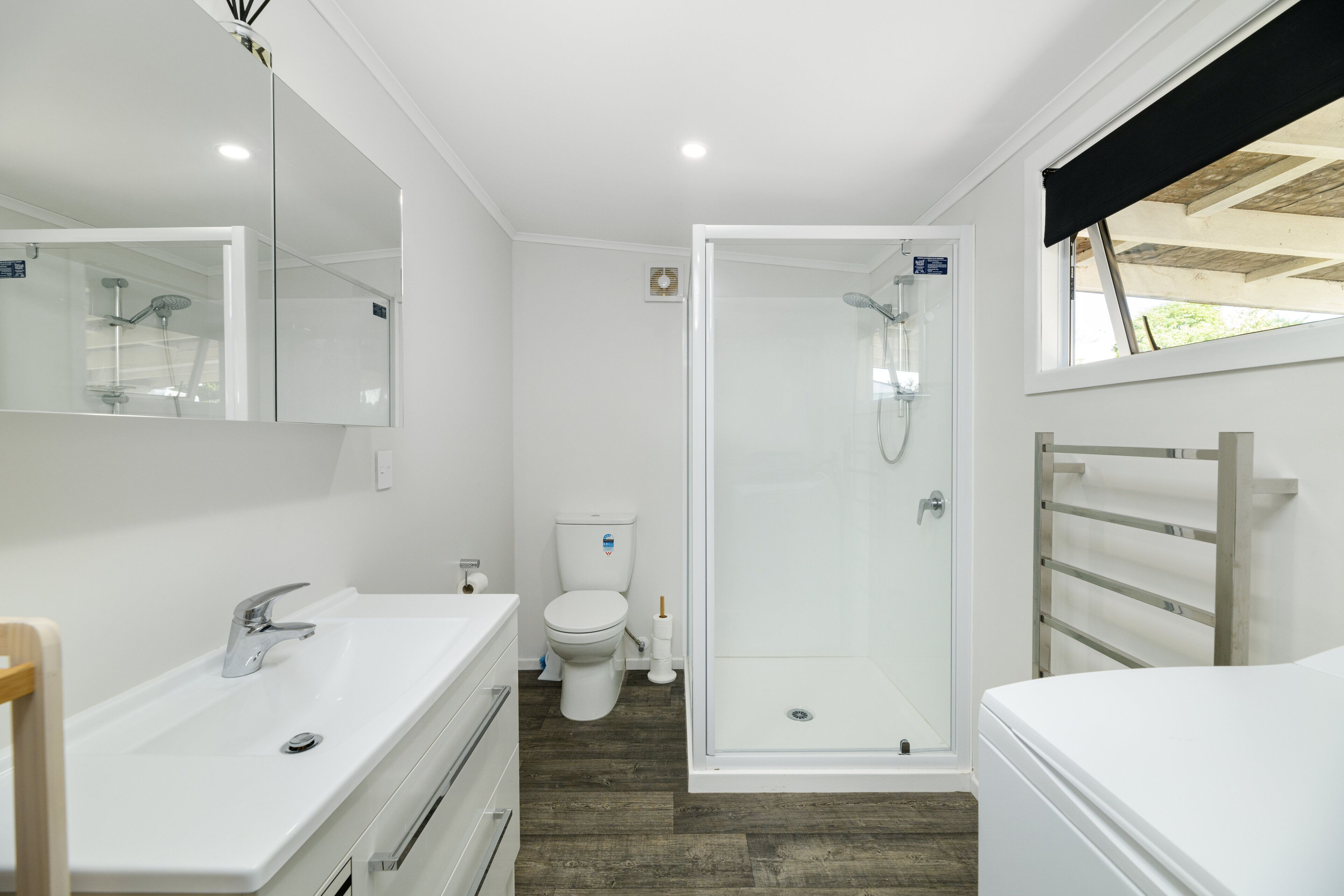 A modern bathroom with a shower, toilet, and sink.