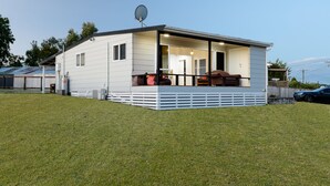 A single-story mobile home with a covered porch and a satellite dish. - LAKE VIEW RETREAT - Relax, Unwind, & Make Memories (Mangakino)