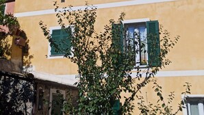 A two-story building with green shutters on windows, a yellow facade, and a clear blue sky. - 2.5 km from the sea of Levanto, on the first hill, in a green and quiet location (levanto)