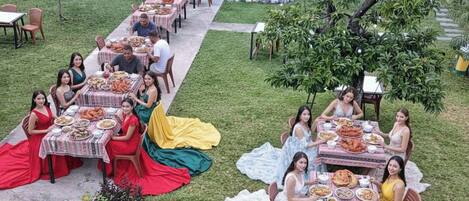 Un espace extérieur aménagé pour les repas, avec des tables disposées pour accueillir un groupe.